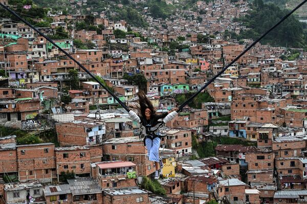 Turist Kolumbiyaning Medellin shahridagi La Comuna 13 mahallasidagi attraksionda sayr qilmoqda. - Sputnik O‘zbekiston