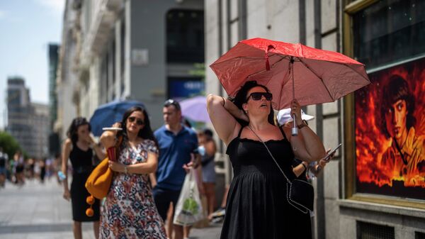Женщина с зонтиком в жаркий солнечный день в Мадриде  - Sputnik Узбекистан