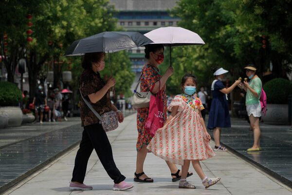 Женщины защищаются от солнца зонтиками.  - Sputnik Узбекистан