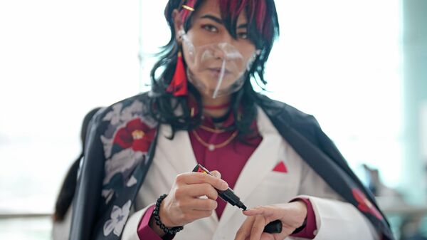 Участник в защитной маске красит ногти на выставке Ani-Com and Games в Гонконге - Sputnik Узбекистан