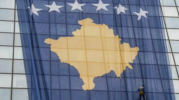 Сотрудник устанавливает гигантский флаг Косово на правительственном здании в Приштине 14 февраля 2018 года в преддверии десятой годовщины независимости Косово - Sputnik Узбекистан