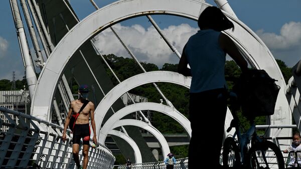 Люди идут по мосту в прибрежном парке в Нью-Тайбэе - Sputnik Ўзбекистон