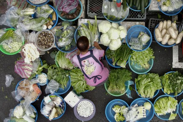 Продавщица сортирует овощи на традиционном рынке Ванда-роуд в Тайбэе. - Sputnik Узбекистан