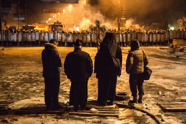 На фото: украинские священнослужители стоят между милицией и оппозицией на нейтральной территории. - Sputnik Узбекистан