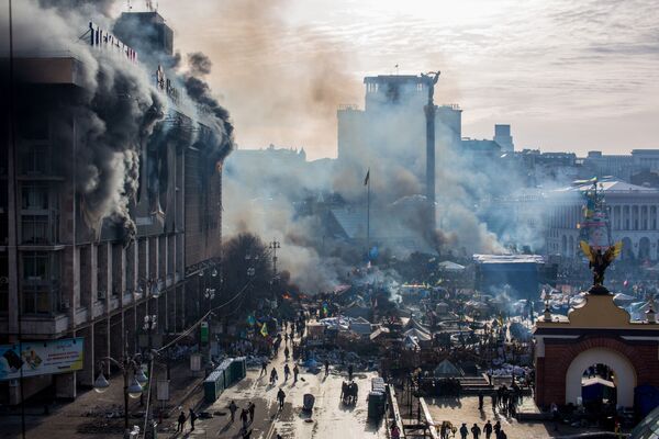 На фото: дым от пожаров и сторонники оппозиции на площади Независимости в Киеве. - Sputnik Узбекистан
