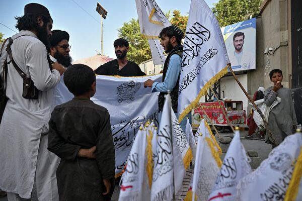 Мужчины покупают флаги талибов на улице в Кабуле. - Sputnik Узбекистан