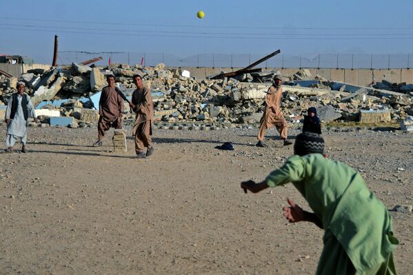 Мальчики играют в крикет перед школой в Кандагаре, которая была повреждена во время конфликта между талибами и прежнем правительством.   - Sputnik Узбекистан