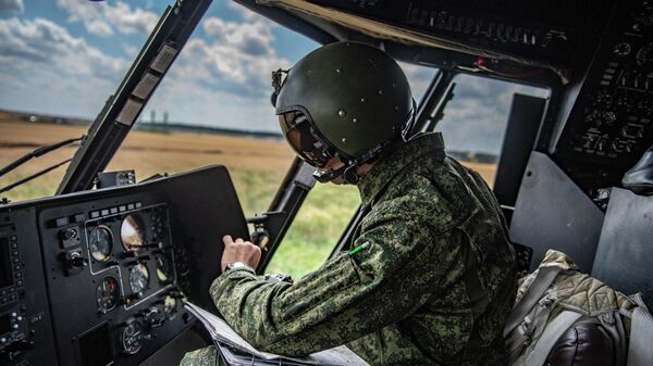 Военный летчик в кабине вертолета Ми-8МТВ на полевом аэродроме - Sputnik Ўзбекистон