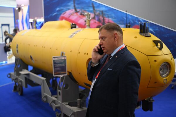 Посетитель разговаривает по телефону у модели подводной лодки на выставке в рамках Международного военно-технического форума &quot;Армия-2022&quot; в конгрессно-выставочном центре &quot;Патриот&quot;. - Sputnik Узбекистан