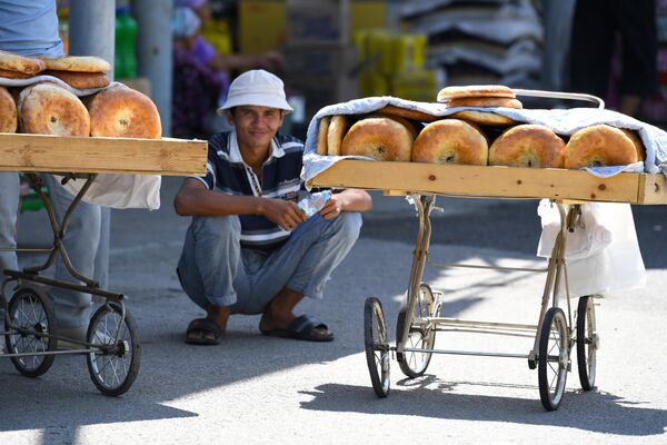Продавец лепешек на рынке. - Sputnik Узбекистан
