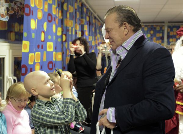 Мальчик фотографирует актера Микки Рурка, который посетил детское онкологическое отделение больницы № 31 - Sputnik Узбекистан