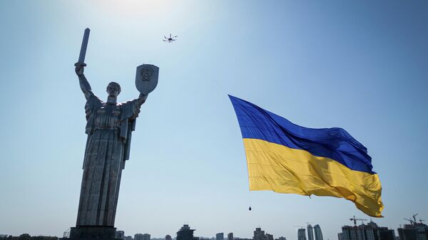 Украинский флаг и монумент Родина-Мать в Киеве, Украина - Sputnik Узбекистан