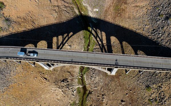 Автомобиль проезжает по мосту через пересохшее озеро Шаста в Калифорнии.  - Sputnik Узбекистан
