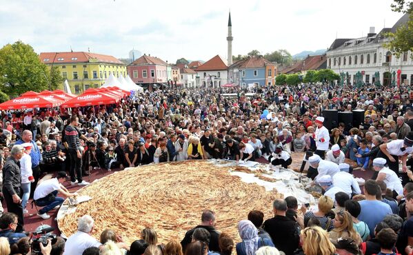 Боснийские повара и их ученики разрезают самый большой в мире бурек на центральной площади в Тузле. - Sputnik Узбекистан