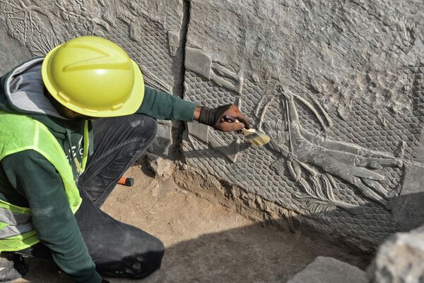 Рабочий очищает мраморную плиту с узором найденную в древнем ассирийском городе Ниневии.  - Sputnik Узбекистан