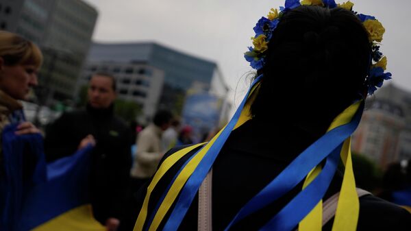 Девушка с ободке в лентами в цвет флага Украины в Брюсселе - Sputnik Узбекистан