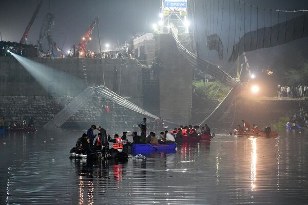 Индийские спасатели проводят поисковые операции после обрушения моста через реку Маччху в Морб. - Sputnik Узбекистан