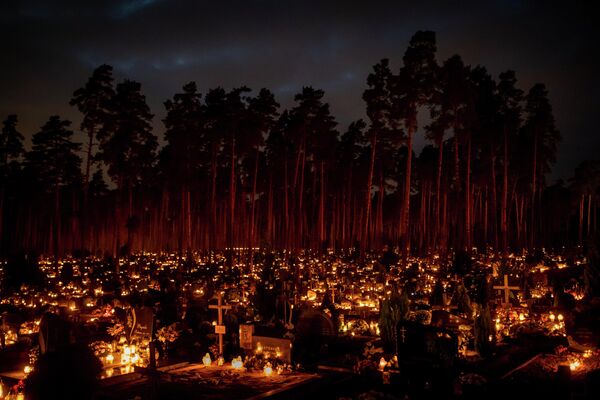 Горящие на могилах свечи в День всех святых на кладбище в Вильнюсе. - Sputnik Узбекистан