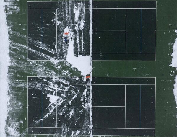 Уборка снега с теннисного корта в Бренчли, юго-восточная Англия. - Sputnik Узбекистан