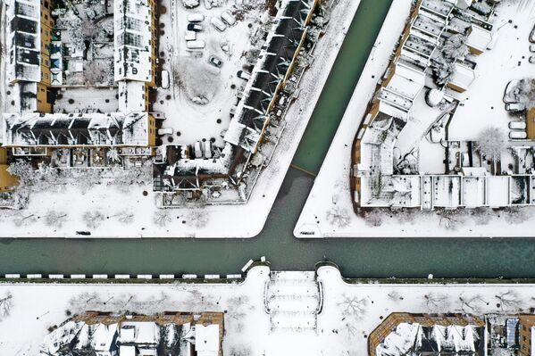 Крыши домов, покрытые снегом, вокруг канала в Уоппинге, восточный Лондон. - Sputnik Узбекистан