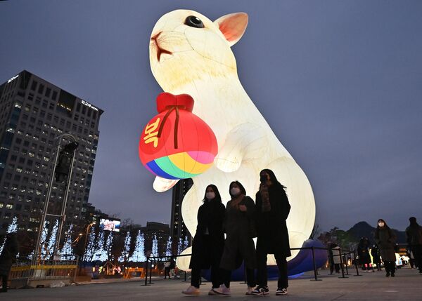 Люди гуляют рядом с огромным фонарем в виде символа наступающего года — кролика. - Sputnik Узбекистан