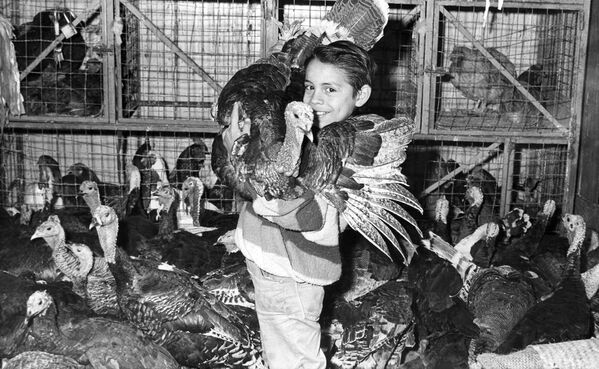 Мексиканский мальчик держит индейку, которую его семья вырастила для Рождества в 1964 году. - Sputnik Узбекистан