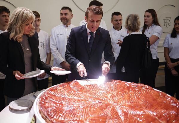 Президент Франции Эммануэль Макрон разрезает Крещенский торт после выступления перед членами Французской федерации хлебобулочных и кондитерских изделий в Елисейском дворце в Париже - Sputnik Узбекистан