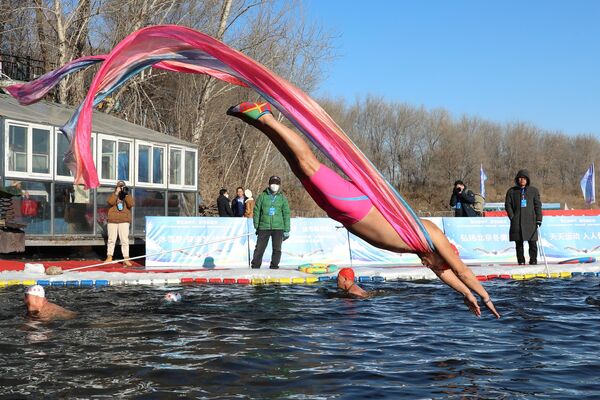 Любитель зимнего плавания ныряет в бассейн в Шэньяне, Китай - Sputnik Узбекистан