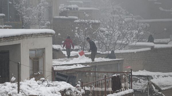 Жители убирают снег с крыши дома во время снегопада в Кабуле, Афганистан - Sputnik Ўзбекистон
