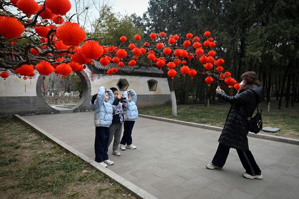 Группа детей позирует перед красными фонарями. - Sputnik Узбекистан