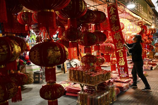Продавец выставляет на продажу китайские фонарики и другие украшения для предстоящего празднования. - Sputnik Узбекистан