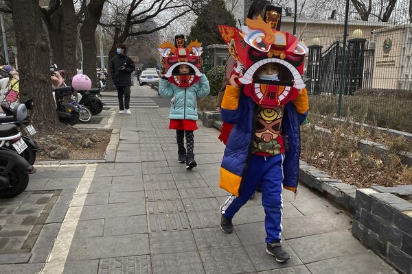 Дети в картонных масках с изображением льва на улицах Пекина. Танец льва — традиционная часть празднования приближающегося Лунного Нового года. - Sputnik Узбекистан