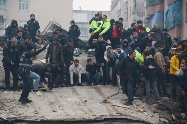 Люди ищут выживших среди завалов в турецком городе Диярбакыр. - Sputnik Узбекистан