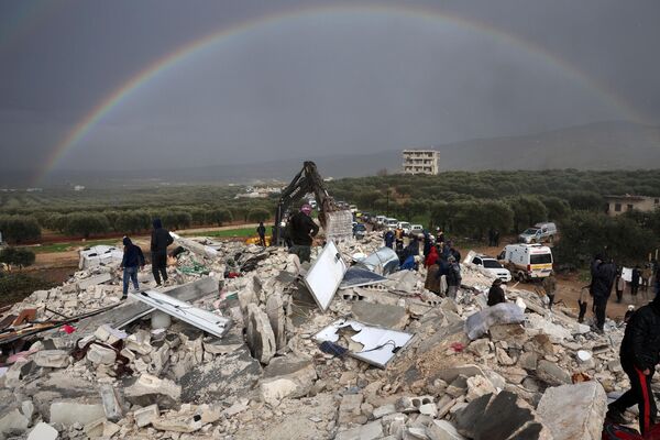 Жители ищут выживших среди обломков рухнувших зданий после  землетрясения в северо-западной сирийской провинции Идлиб на границе с Турцией 6 февраля 2022  года. - Sputnik Узбекистан