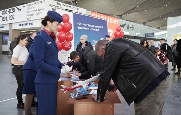 Сотрудники аэропорта проводят праздничную лотерею на мероприятиях в честь празднования 100-летия гражданской авиации в аэропорту Пулково - Sputnik Узбекистан