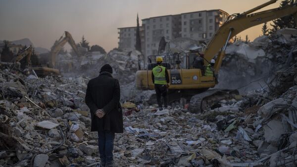 Мужчина стоит на обломках своего дома, разрушенного во время землетрясения в Антакье, юго-восточная Турция, воскресенье, 12 февраля 2023 года - Sputnik Узбекистан