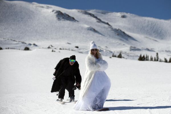 Молодожены празднуют свадьбу, катаясь на лыжах в горнолыжном районе Лавленд в штате Колорадо. - Sputnik Узбекистан