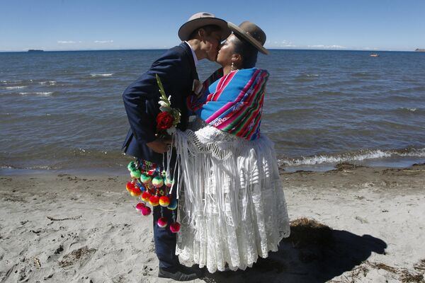 Эквадорец Брайан Росел и его жена Магдалена Льянке позируют для фото во время массовой свадебной церемонии в Перу. - Sputnik Узбекистан