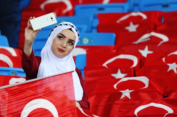 Болельщица сборной Турции фотографируется на зрительской трибуне перед началом матча  - Sputnik Узбекистан