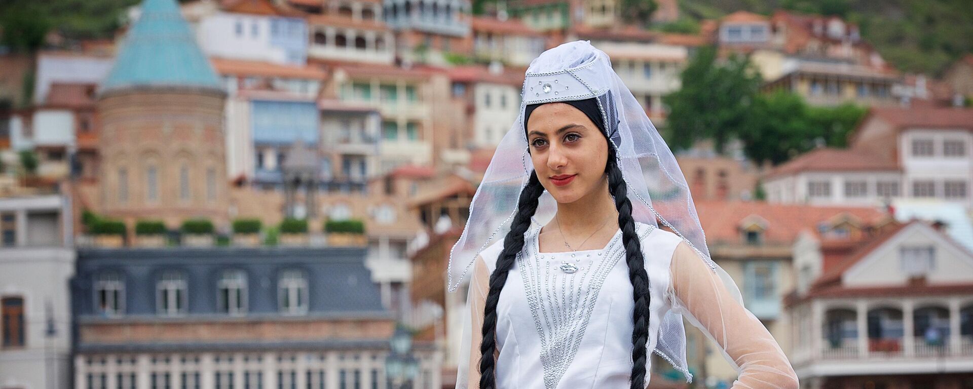 Uchastnitsa shestviya, priurochennogo k prazdnovaniyu Dnya natsionalnogo kostuma, v Tbilisi, Gruziya - Sputnik O‘zbekiston, 1920, 09.03.2026