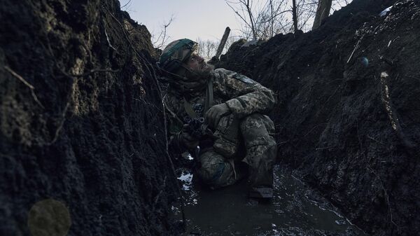 Soldat VSU prachetsya v transhee vo vremya obstrela pod Artemovskom. Arxivnoe foto - Sputnik O‘zbekiston