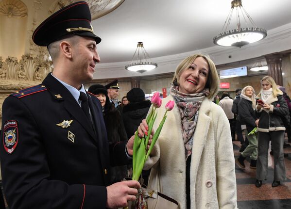 Сотрудник УВД на Московском метрополитене поздравляет женщину с наступающим 8 марта  - Sputnik Узбекистан