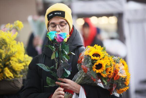 Молодой покупает цветы в преддверии Международного женского дня - Sputnik Узбекистан