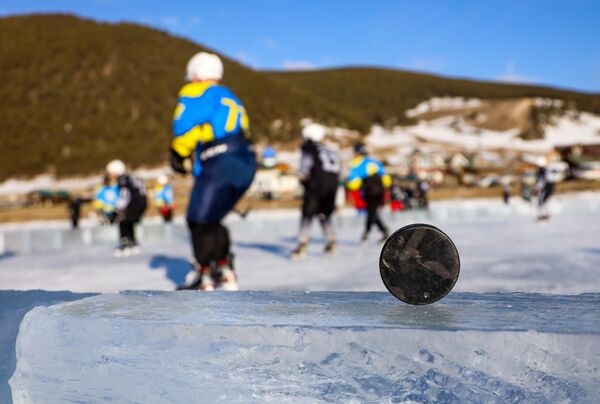 Шайба на бортике изо льда на площадке, где проходит звездный хоккейный матч. - Sputnik Узбекистан