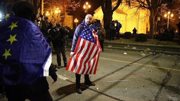Мужчина с флагом США на протестах в Тбилиси 9 марта 2023 года. - Sputnik Ўзбекистон