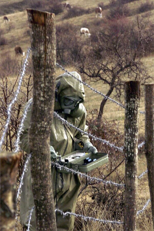 Cолдат югославской армии измеряет радиоактивность в зоне бомбардировки, Прешево, Сербия, 2001 год. - Sputnik Узбекистан