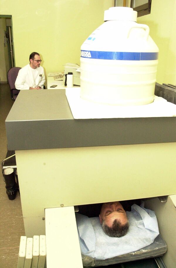 Хорватский инженер проверяет приборы во время медицинского осмотра члена группы по разминированию Бруно Михайловича на приборе, измеряющем излучение всего тела, в Институте ядерной медицины в Загребе, январь 2001 года. - Sputnik Узбекистан