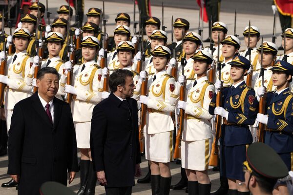 Председатель Китая Си Цзиньпин и его французский коллега Эммануэль Макрон осматривают почетный караул во время официальной церемонии встречи.  - Sputnik Узбекистан