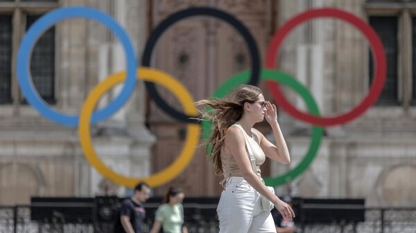 Jenshina proxodit mimo olimpiyskix koles u merii Parija. Arxivnoe foto - Sputnik O‘zbekiston