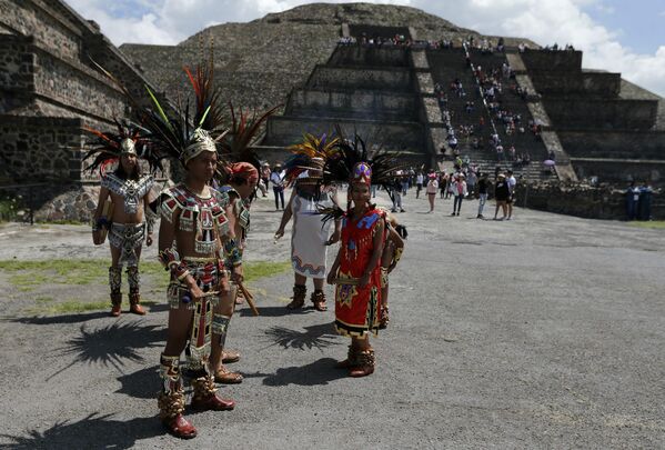 Танцоры ацтеков ждут начала церемонии зажжения огня Pan Am на археологических раскопках Теотиуакан, Мексика. - Sputnik Узбекистан